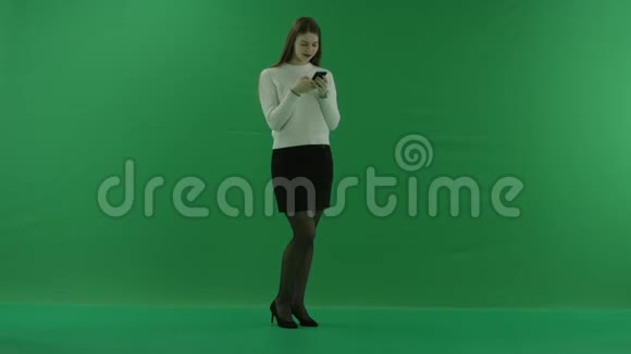女孩正站在半个转弯处看着右边在绿色屏幕上发短信说手机上有什么好东西视频的预览图