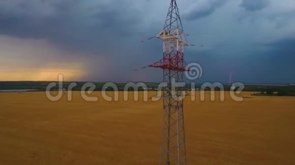 地平线上巨大的风暴云发出闪电前方麦田上的电线杆视频的预览图