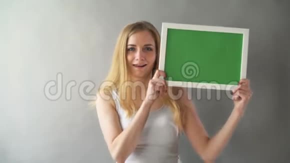 有吸引力的女人显示绿色钥匙复制空间与跟踪点女孩手里拿着发色的盘子视频的预览图