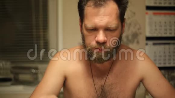 白种人长胡子的男人坐在桌子旁厨房里有叉子自制食物视频的预览图