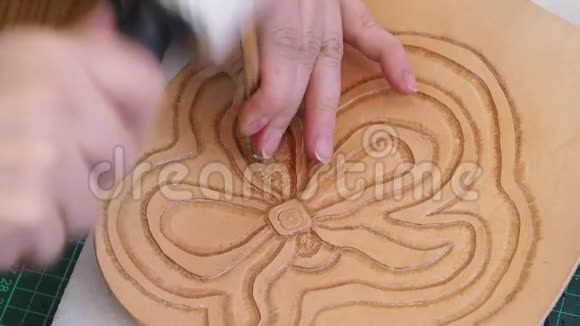 工匠用背景冲压工具和木槌在皮革上印花视频的预览图