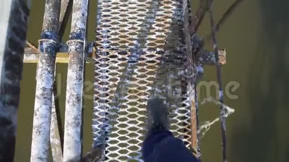 男人走过桥拍他的腿的视频视频的预览图
