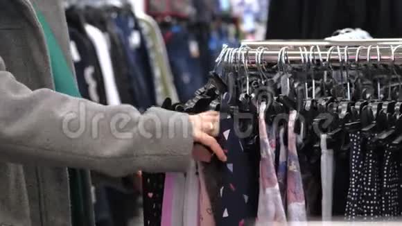 妇女为商店里的孩子挑选衣服视频的预览图