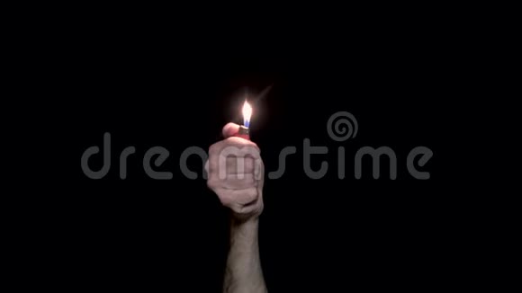 人的特写他的手点燃了打火机在黑色背景上点燃打火机黑暗中的光明象征着记忆和团结视频的预览图