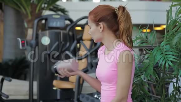 在健身房喝鸡尾酒的红发女人的肖像视频的预览图