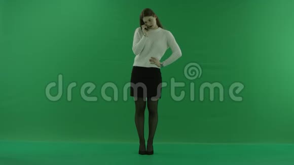 女孩站直了身子在绿色屏幕上打电话视频的预览图