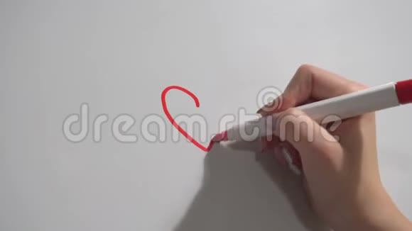女性的手用记号笔快速地在塑料板上画出心脏视频的预览图