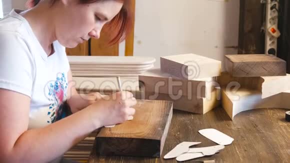 女人把纸模板重新涂到木条上视频的预览图