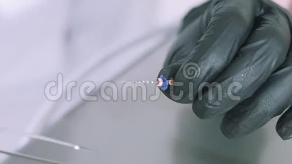 一个戴着医用手套的牙医的特写慢镜头仔细观察了这个钻头的牙科单元转动视频的预览图