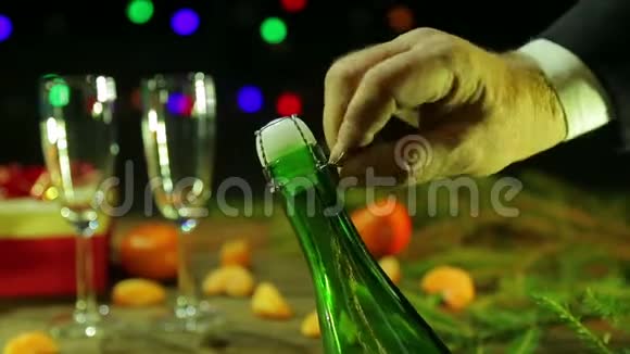 雄手从一瓶香槟中拧开软木塞视频的预览图