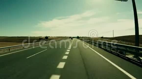 在阳光明媚的夏日西班牙中部一条高速公路上的POV驾驶镜头视频的预览图