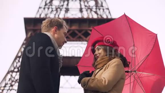 美丽的年轻情侣在雨伞下温柔接吻在巴黎浪漫约会视频的预览图