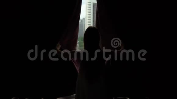 在市中心的公寓里一位成功的富有的年轻女子拉开了窗帘尽收眼底视频的预览图