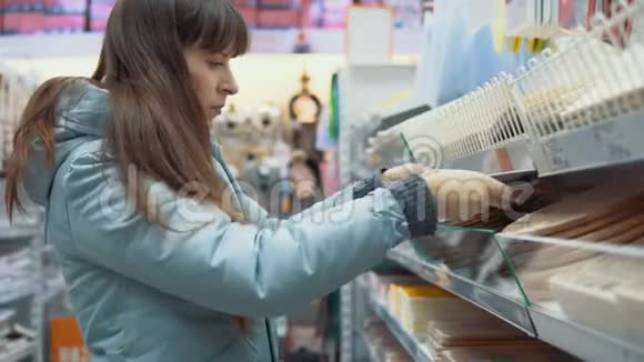 一个年轻的女人在商店里选择伍登切割板视频的预览图