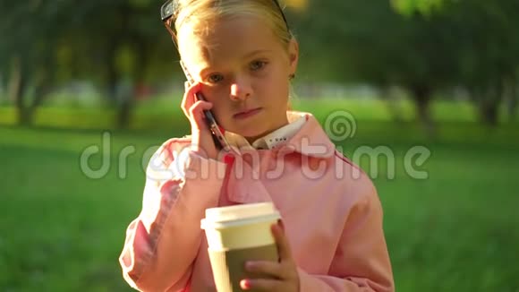 可爱的粉红色小女孩站着打电话视频的预览图