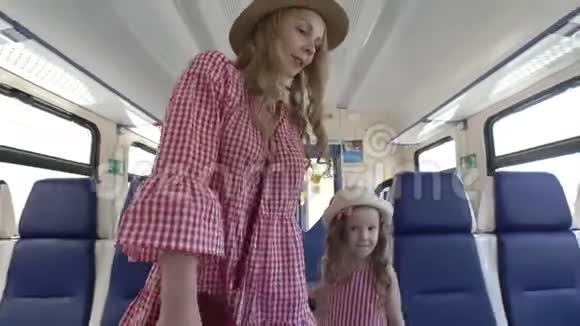 漂亮的年轻女子和她的小女儿坐着空车散步视频的预览图