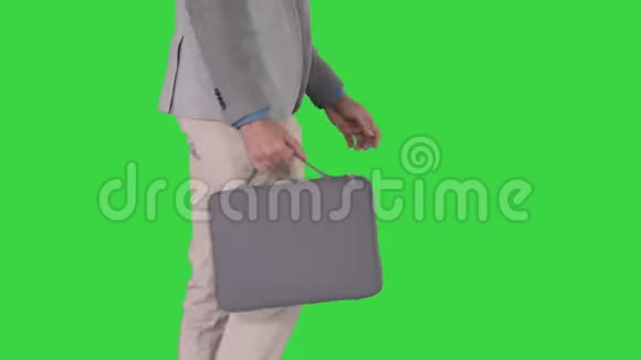 一个穿着休闲装的男人拿着绿色屏幕上的公文包按着Chroma键视频的预览图