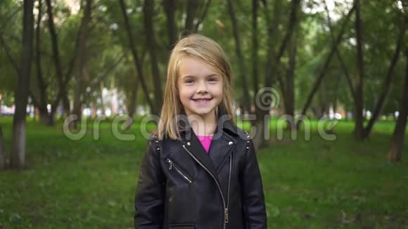 快乐的小女孩在公园里微笑和空中亲吻视频的预览图