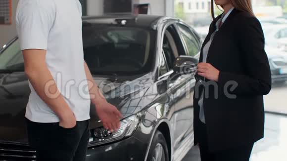 家庭之手把汽车钥匙交给男性手在汽车经销店关门不承认的汽车销售商和一个视频的预览图
