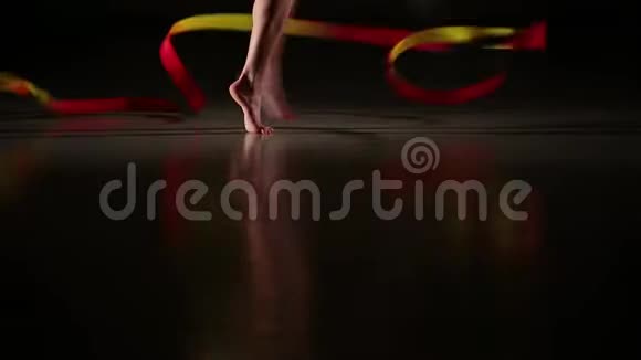 女运动员用彩带表演艺术体操元素的特写纤细的腿视频的预览图