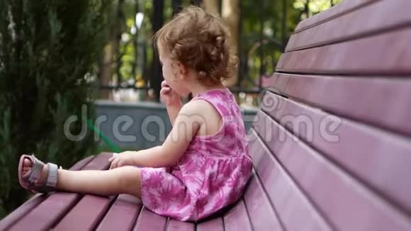 小快乐的孩子笑着在长凳上的公园里玩耍视频的预览图