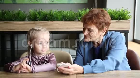 祖母带着耳机给孙女听音频故事视频的预览图