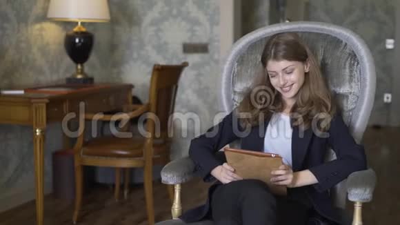 豪华酒店客房内有一位漂亮的女商人带着数码平板电脑视频的预览图