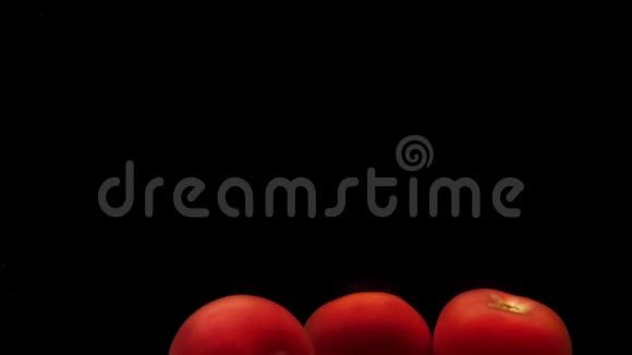 三个红色的假名躺在透明的水里黑色的背景视频的预览图