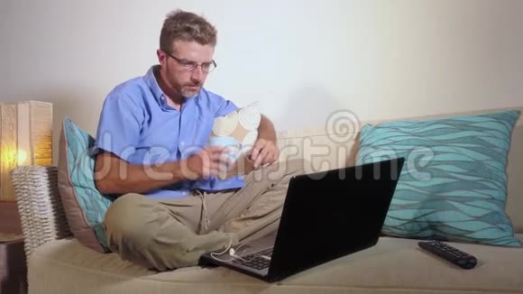 慢慢放大年轻迷人的集中商人穿着休闲服装在家用笔记本电脑工作视频的预览图