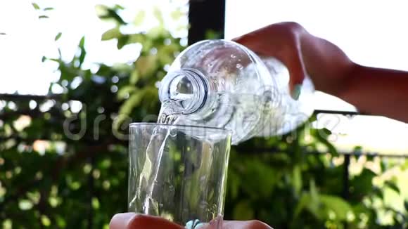 灌一杯清水一个女人从瓶子里倒水的慢速特写镜头视频的预览图
