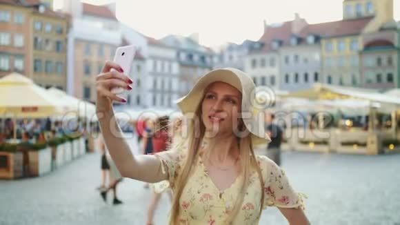 女人在广场自拍迷人的女人摆出自拍和站在城市广场视频的预览图