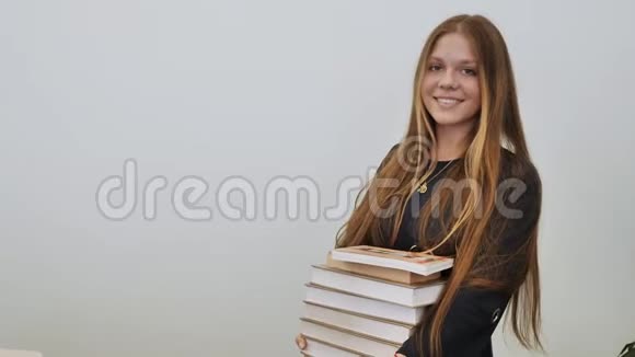 一个心情好的女学生拿着一堆书视频的预览图