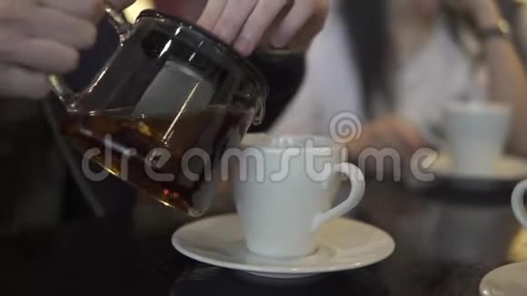 一个人把茶从茶壶里倒进杯子里视频的预览图