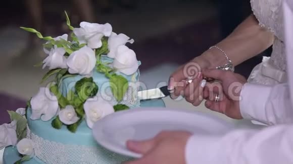 新婚夫妇用花切了一个漂亮的白色婚礼蛋糕视频的预览图