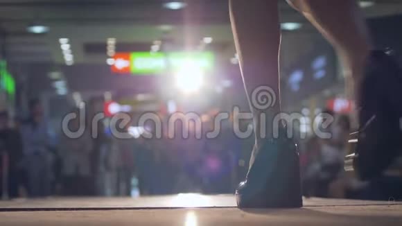模特穿着裙子和高跟鞋在灯光下展示新系列的衣服时玷污了T台步视频的预览图