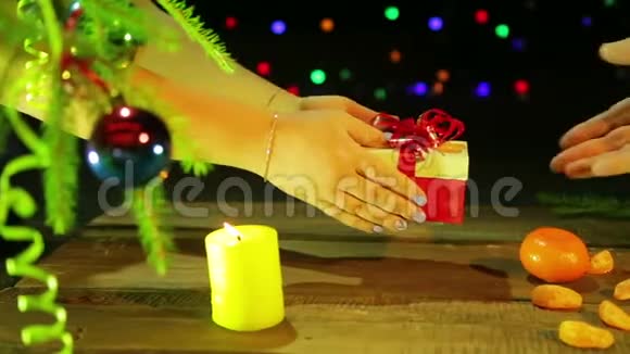 一只雌性手把一个盒子和一个圣诞礼物递给一个男人视频的预览图