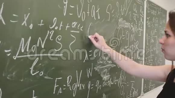女学生在黑板上写下数学公式并在摄像机前摆出姿势视频的预览图