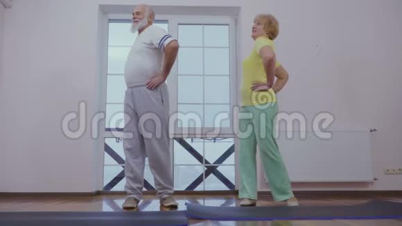 老年男子和老年妇女在家做运动视频的预览图