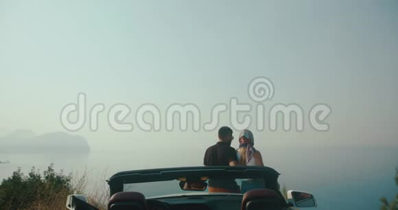 浪漫的公路旅行时尚的男人和女人站在黑山某处的汽车前欣赏美丽的风景视频的预览图