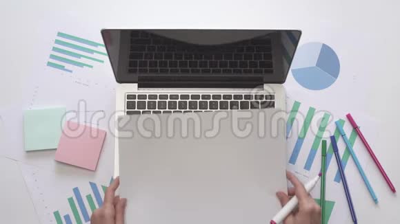 女人在笔记本电脑上的一张纸上写工资上景视频的预览图