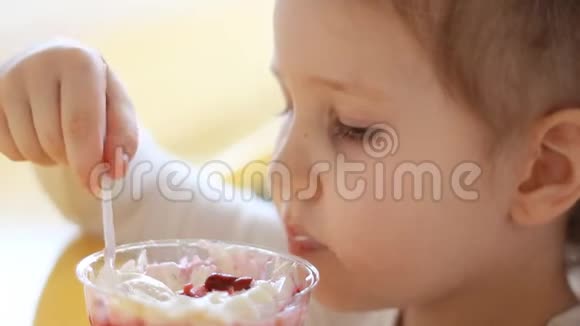 小女孩在咖啡馆里吃甜点吃冰淇淋的婴儿的肖像特写视频的预览图