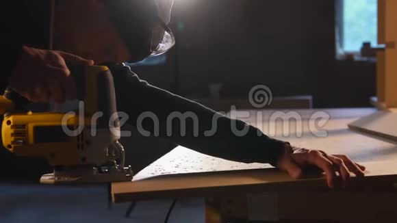 在一家小企业里木匠拿着电刀做木材加工视频的预览图