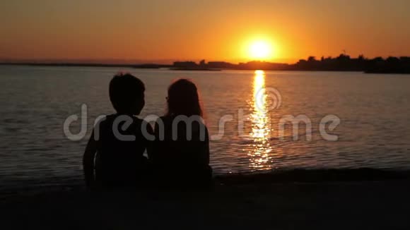 男孩和女孩正在看海上的日落视频的预览图