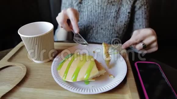 时髦的女孩坐在咖啡馆里吃着带糖浆的煎饼喝着覆盆子茶视频的预览图
