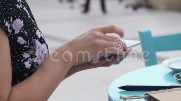 在户外咖啡馆里女人在智能手机上使用移动应用程序发短信发电子邮件视频的预览图