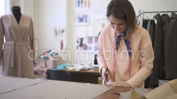 女裁缝用剪刀剪出剪刀并增加缝纫材料视频的预览图