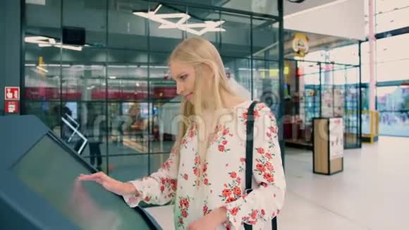 年轻女性在现代商场的导航板上寻找正确的方向视频的预览图