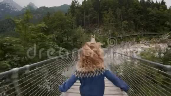 年轻女子探索史诗吊桥视频的预览图