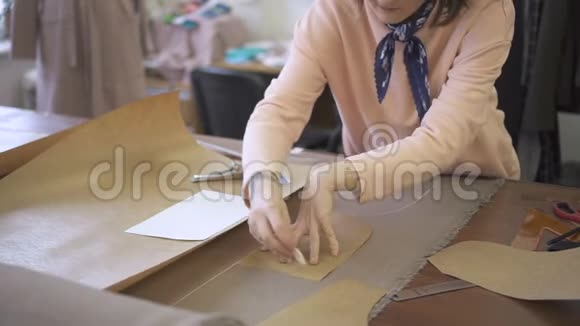 在桌子上裁缝用粉笔在缝纫材料上画了一个图案视频的预览图
