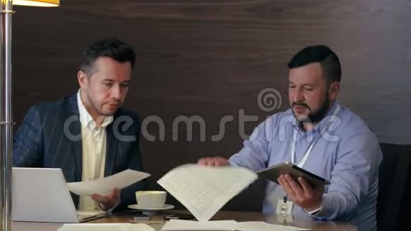 两位男企业家在办公室会议上喝咖啡时交谈视频的预览图